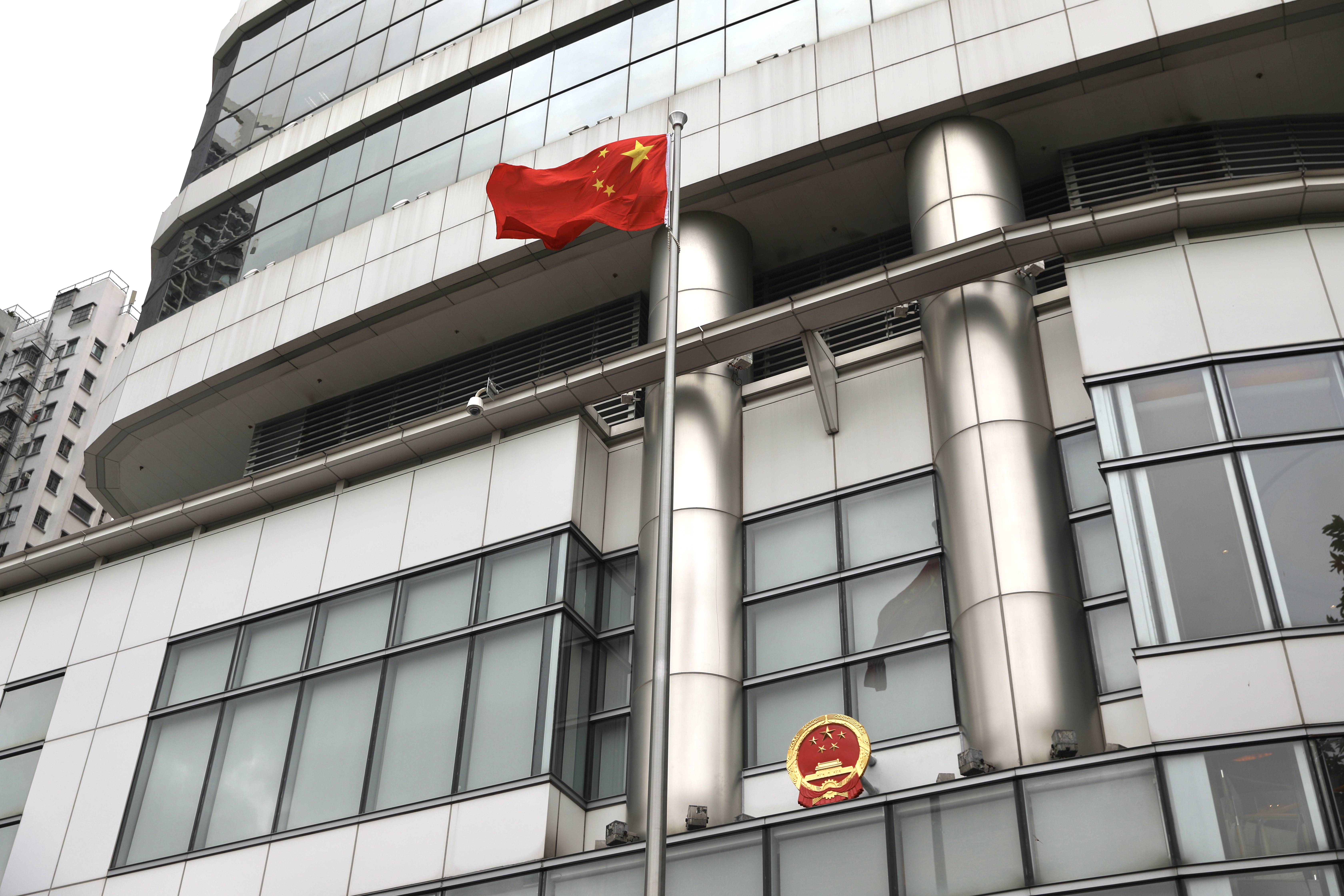 維景酒店的大樓外早已掛上中華人民共和國國徽，早上7時許，在大樓外的旗桿台，工作人員升起五星旗，數十名嘉賓圍攏站立在旗桿台旁邊，觀看五星旗徐徐升起。約半小時後，駐港公署要員及特首，先後發表講話。（點新聞記者李斯哲攝）