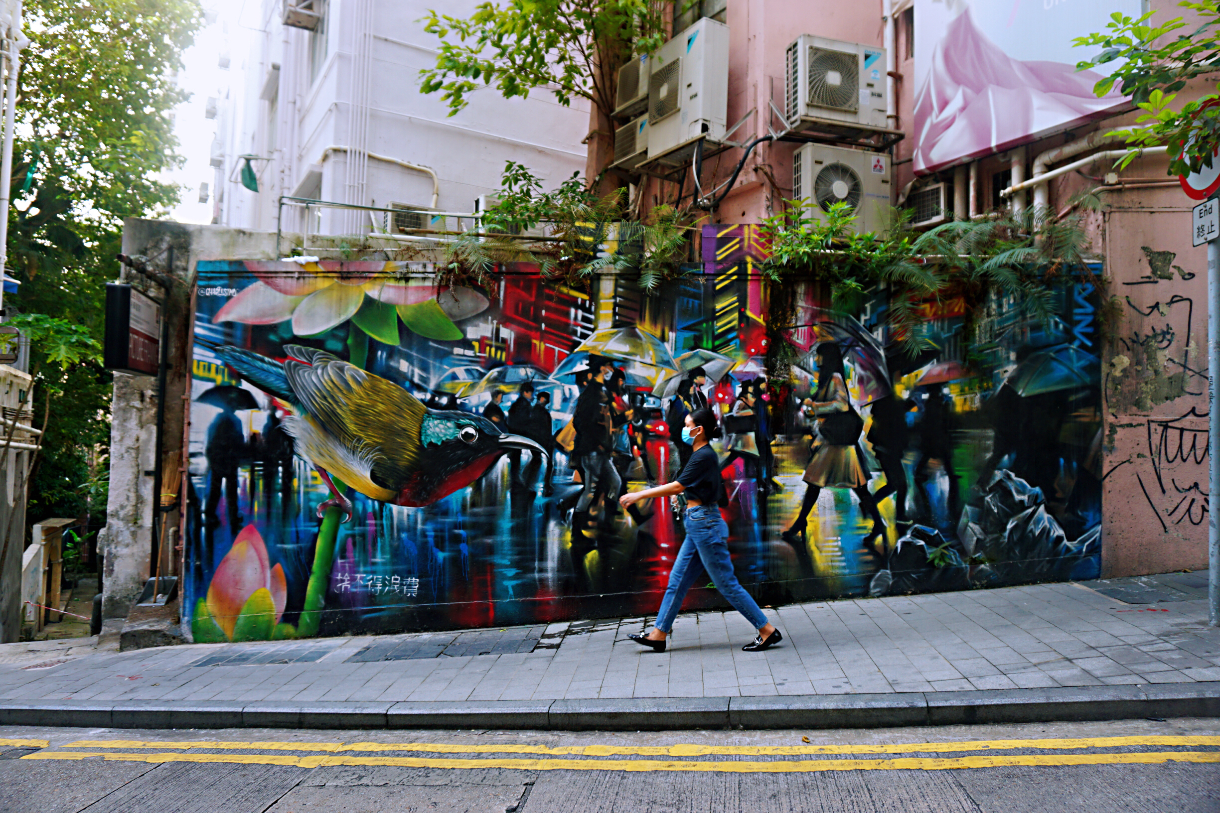 中環伊利近街上描繪雨夜中都市景觀的壁畫，左下方寫着「捨不得浪費」的字句。