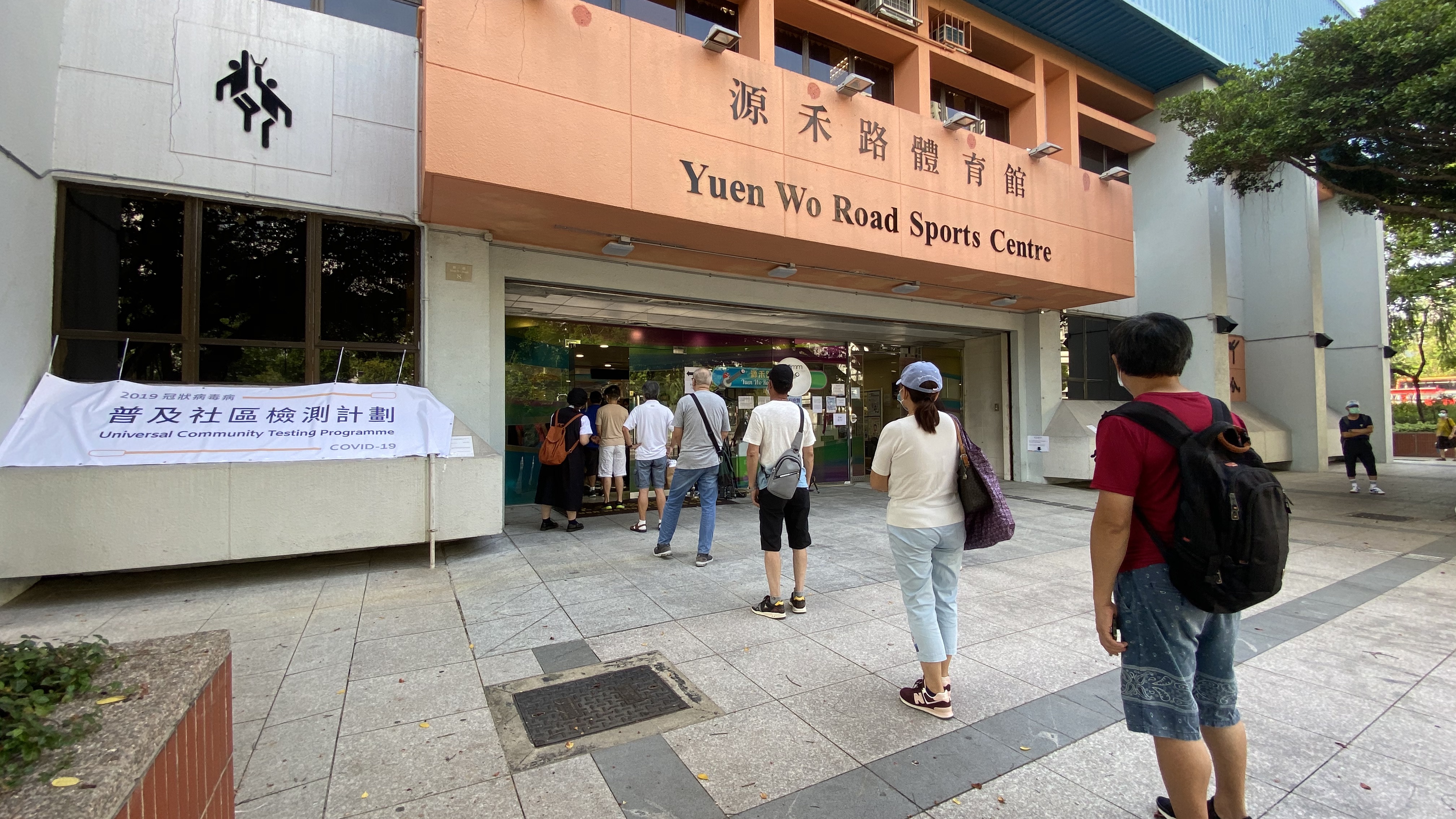 普及社區檢測計劃今日（1日）正式展開，市民參與踴躍。在沙田源禾路體育館檢測點，已經有不少預約市民等候檢測。市民在入口排隊，有保持社交距離，現場秩序井然。在進入檢測點後，市民要先測量體溫。