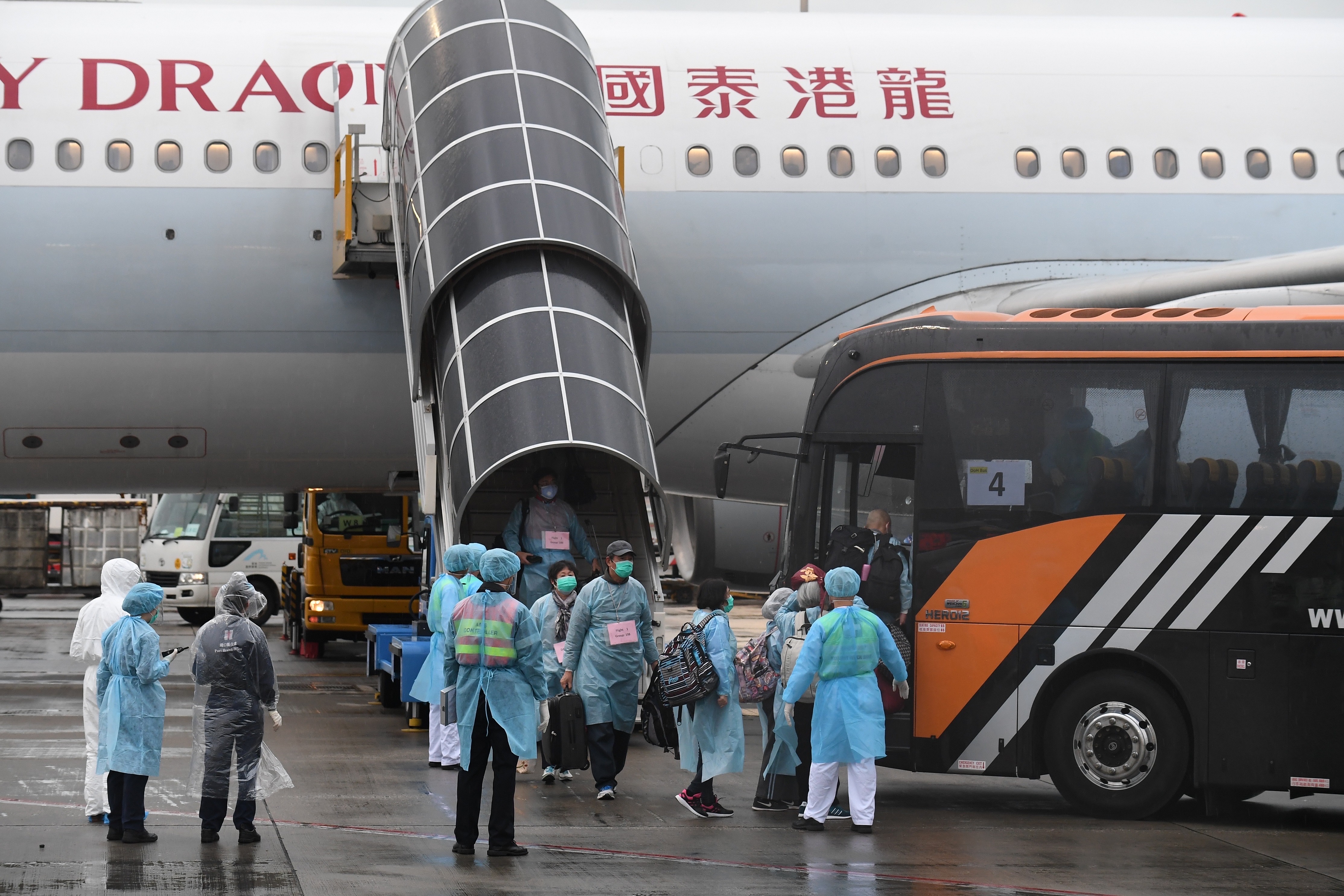 3月4日，接載滯留湖北港人返港的首班包機抵達香港國際機場後，乘客下機登上專車前往隔離地點。（新華社資料圖片）