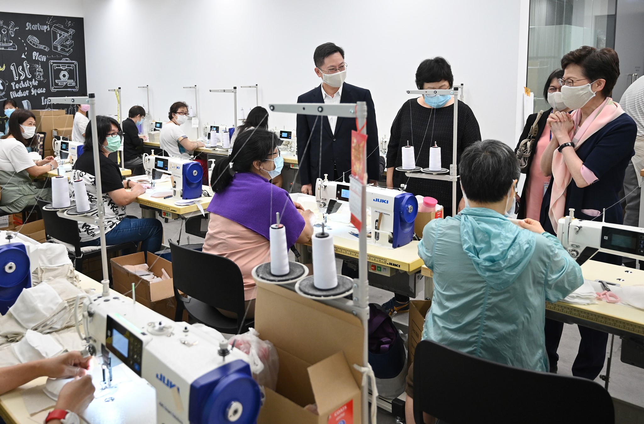 5月5日，政府公布六項增加口罩供應的措施，包括向全港市民每人派發一個「銅芯抗疫」可重用口罩和每戶派發10個一次性口罩。圖為特首林鄭月娥赴工廠視察銅芯口罩生產情況。（政府新聞處資料圖片）